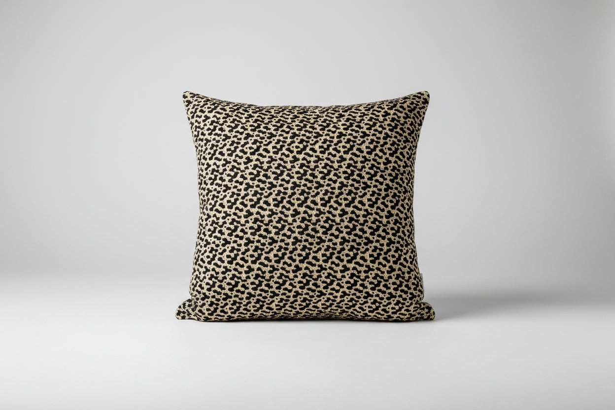 A square-shaped pillow with a dark green and cream color pattern featuring a leopard animal print.
